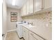 Functional laundry room with modern washer and dryer, herringbone backsplash, and sink at 10520 Boardwalk Loop # 205, Lakewood Ranch, FL 34202