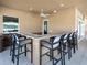 Outdoor bar area featuring a spacious counter, comfortable seating, and a ceiling fan at 10520 Boardwalk Loop # 205, Lakewood Ranch, FL 34202