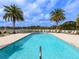 Beautiful swimming pool surrounded by lounge chairs and palm trees on a sunny day at 10520 Boardwalk Loop # 205, Lakewood Ranch, FL 34202