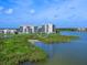 Picturesque view of two waterfront condo buildings surrounded by lush greenery and serene waters at 10520 Boardwalk Loop # 205, Lakewood Ranch, FL 34202