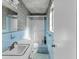 Bathroom with blue tiled walls and a shower with glass doors at 1103 Palma Sola Blvd, Bradenton, FL 34209