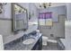 Classic bathroom with granite-topped vanity, tiled walls, and a decorative chandelier at 1103 Palma Sola Blvd, Bradenton, FL 34209