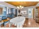 Open dining room features hardwood floors, wood paneled ceiling, chandelier, and pass-through to kitchen at 1103 Palma Sola Blvd, Bradenton, FL 34209