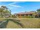 Charming single-story home featuring a well-manicured lawn, trimmed shrubbery, and a classic chimney, set beneath a bright blue sky at 1103 Palma Sola Blvd, Bradenton, FL 34209
