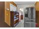 Hallway with built-in shelving leads to bathroom with stainless steel refrigerator to the side at 1103 Palma Sola Blvd, Bradenton, FL 34209