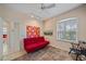Guest room featuring bright floral artwork, red futon, neutral decor, and ample natural light at 11910 Soft Rush Ter, Lakewood Ranch, FL 34202