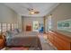 Cozy bedroom with access to the screened lanai, wood floors, and mid-century modern furniture at 11910 Soft Rush Ter, Lakewood Ranch, FL 34202