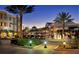 Nighttime view of the community center with fountains, palm trees, and string lights at 11910 Soft Rush Ter, Lakewood Ranch, FL 34202
