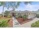 Charming single-story home with a beautifully landscaped front yard and inviting red front door at 11910 Soft Rush Ter, Lakewood Ranch, FL 34202