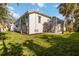 Spacious backyard with lush lawn and house exterior featuring a screened-in pool area at 121 N Boulevard Of Presidents, Sarasota, FL 34236