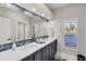 Bathroom vanity with double sinks, quartz countertop, custom mirror and blue-grey cabinets at 121 N Boulevard Of Presidents, Sarasota, FL 34236