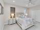 Cozy bedroom featuring a queen bed with light grey bedding, dual nightstands, and a ceiling fan at 121 N Boulevard Of Presidents, Sarasota, FL 34236