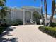 Beautiful home featuring a brick paved driveway, charming architectural details, and lush tropical landscaping at 121 N Boulevard Of Presidents, Sarasota, FL 34236