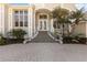 Inviting entryway with a paved walkway, decorative railings, and a covered porch with large glass paneled doors at 121 N Boulevard Of Presidents, Sarasota, FL 34236