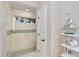 Beautiful walk-in shower with glass door, tiled walls, a built-in seat, and decorative blue accents at 121 N Boulevard Of Presidents, Sarasota, FL 34236