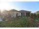 The backyard of this home features a screened-in porch, lush landscaping, and partial fencing at 12286 23Rd E St, Parrish, FL 34219