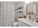 Bright bathroom featuring a vanity with modern faucet, patterned shower curtain, and storage shelves at 14 Tidy Island Blvd, Bradenton, FL 34210