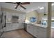 Bright kitchen featuring white cabinets, stainless steel appliances, and a breakfast bar overlooking the living area at 14 Tidy Island Blvd, Bradenton, FL 34210