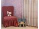 Charming detail of bedroom with chair and dollhouse against pink wallpaper at 1510 Lena Ln, Sarasota, FL 34240