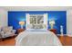 Well-lit bedroom with a plush armchair, bedside tables, and a bright blue accent wall at 1510 Lena Ln, Sarasota, FL 34240