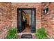 Open front door reveals a charming interior, brick entrance with a welcome mat for a warm and inviting feel at 1510 Lena Ln, Sarasota, FL 34240