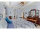 Inviting main bedroom with tray ceilings featuring an en-suite bathroom and large dresser at 16422 Rivers Reach Blvd, Parrish, FL 34219