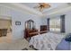 Serene main bedroom featuring a tray ceiling, a large window, and an adjacent en-suite bathroom at 16422 Rivers Reach Blvd, Parrish, FL 34219