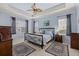 Tranquil main bedroom features a ceiling fan, tray ceiling, and ample natural light at 16422 Rivers Reach Blvd, Parrish, FL 34219