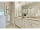 Bathroom with double vanity, decorative wallpaper, and walk-in shower at 260 Van Gogh Cv, Bradenton, FL 34212