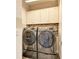 Organized laundry room with a front-load washer and dryer and overhead cabinetry at 260 Van Gogh Cv, Bradenton, FL 34212