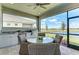 Relaxing screened patio featuring a dining table and an outdoor kitchen with scenic views at 260 Van Gogh Cv, Bradenton, FL 34212