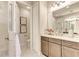 Bright bathroom featuring double sinks, a large mirror, and a separate toilet room at 264 Van Gogh Cv, Bradenton, FL 34212