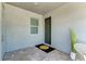 Cozy covered porch with tiled flooring, green front door and a view of the landscaped outdoors at 264 Van Gogh Cv, Bradenton, FL 34212
