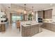 Elegant kitchen with a waterfall island, stainless steel appliances, and an open view into the living area at 264 Van Gogh Cv, Bradenton, FL 34212