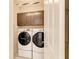 Modern laundry room equipped with a washer and dryer set and overhead storage cabinets at 264 Van Gogh Cv, Bradenton, FL 34212