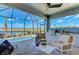 Relaxing screened-in patio with outdoor kitchen, comfortable seating, and a beautiful view of the pool and waterfront at 264 Van Gogh Cv, Bradenton, FL 34212