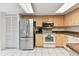 Charming kitchen featuring tile floors, stainless steel refrigerator, and neutral-toned cabinets at 2774 71St St Ct W # 2101, Bradenton, FL 34209