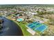 Aerial view of community pool, lake, and tennis courts surrounded by neighborhood homes at 279 Park Forest Blvd, Englewood, FL 34223