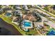 Aerial view of community clubhouse, pool and spa with ample parking and green spaces at 279 Park Forest Blvd, Englewood, FL 34223