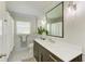 Modern bathroom with marble countertop, dark wood cabinets, and a decorative mirror at 279 Park Forest Blvd, Englewood, FL 34223