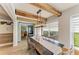 Well-lit dining room featuring wooden beams and a sliding barn door leading to the patio at 279 Park Forest Blvd, Englewood, FL 34223