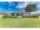 Home's exterior view showcasing the manicured lawn, trimmed hedges, and pleasant patio area at 279 Park Forest Blvd, Englewood, FL 34223