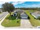 Aerial view of a house featuring an attached garage, a nearby pond, and neatly kept landscaping at 279 Park Forest Blvd, Englewood, FL 34223