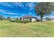 Exterior home view, lush lawn, trimmed hedges, complete with a charming outdoor patio setup at 279 Park Forest Blvd, Englewood, FL 34223