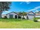 Charming single-story home with a well-manicured lawn, mature landscaping, and neutral color palette at 279 Park Forest Blvd, Englewood, FL 34223