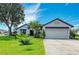 Charming single-story home with a well-manicured lawn, mature tree, and a two-car garage at 279 Park Forest Blvd, Englewood, FL 34223
