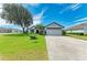 Charming single-story home with a well-manicured lawn, mature tree, and a two-car garage at 279 Park Forest Blvd, Englewood, FL 34223