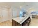 Kitchen island featuring a marble countertop, barstool seating, sink, and modern pendant lighting at 279 Park Forest Blvd, Englewood, FL 34223