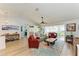 Spacious living room with vaulted ceiling, wood floors, and an open layout to the dining area at 279 Park Forest Blvd, Englewood, FL 34223