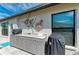 Outdoor kitchen with marble countertops, grill, and decorative turtle wall art at 279 Park Forest Blvd, Englewood, FL 34223